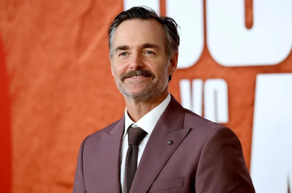 A man smiling at a movie premiere red carpet event