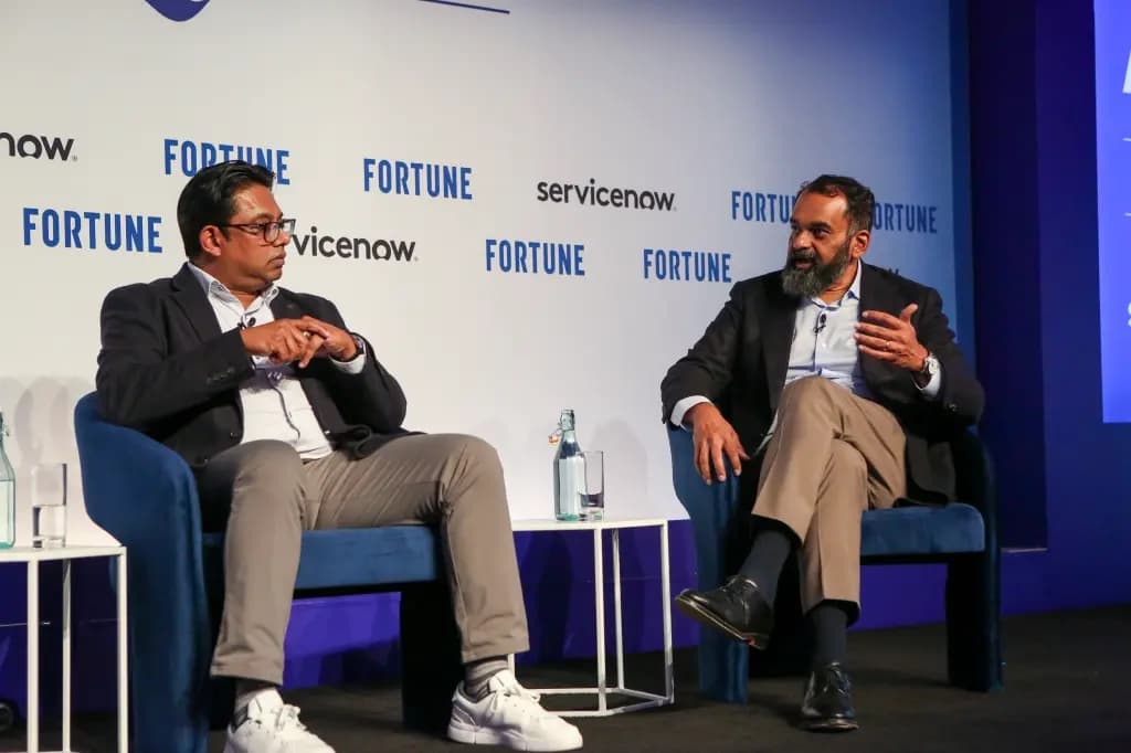 Two executives seated on stage in conversation at a Fortune conference
