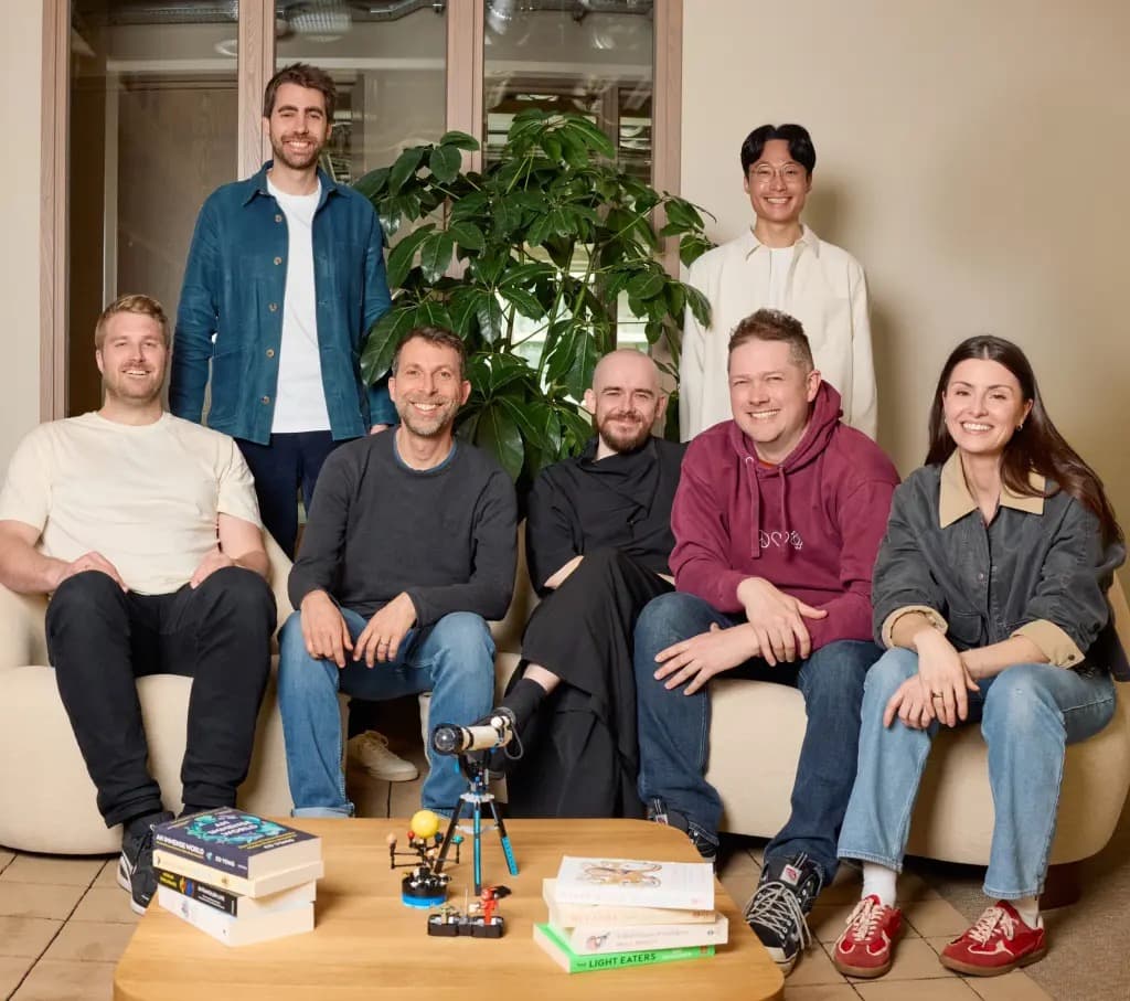 The seven cofounders of Ineffable Intelligence posing together in an office lounge