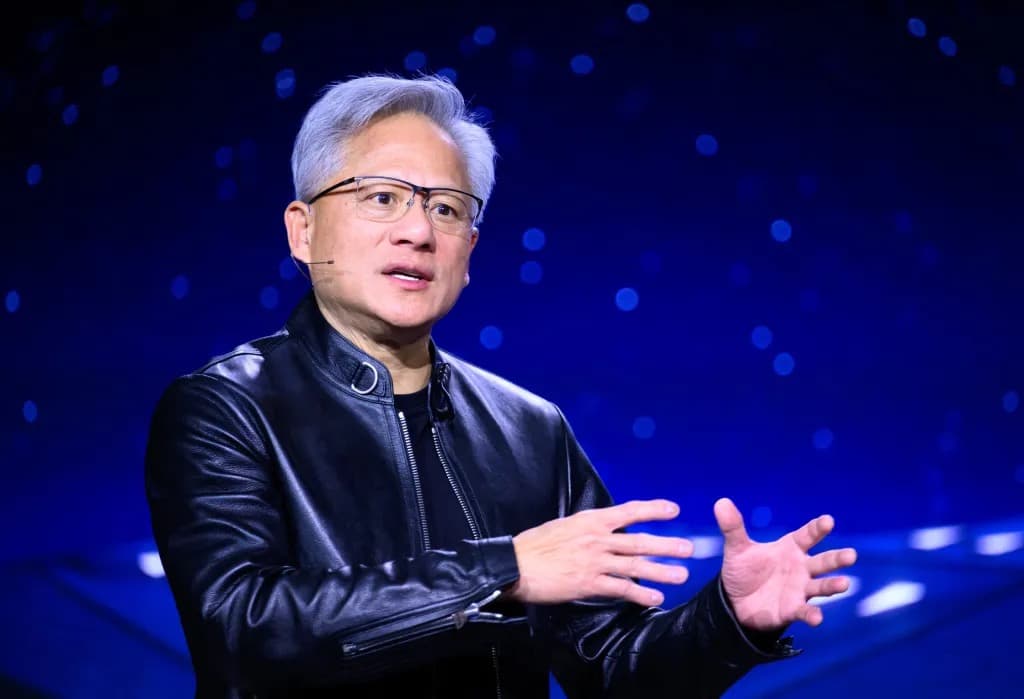Nvidia CEO Jensen Huang gesturing while speaking on stage against a blue starlit backdrop
