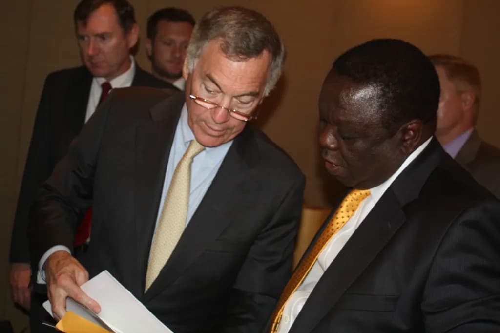 Steve Hanke conferring with another man while reviewing documents