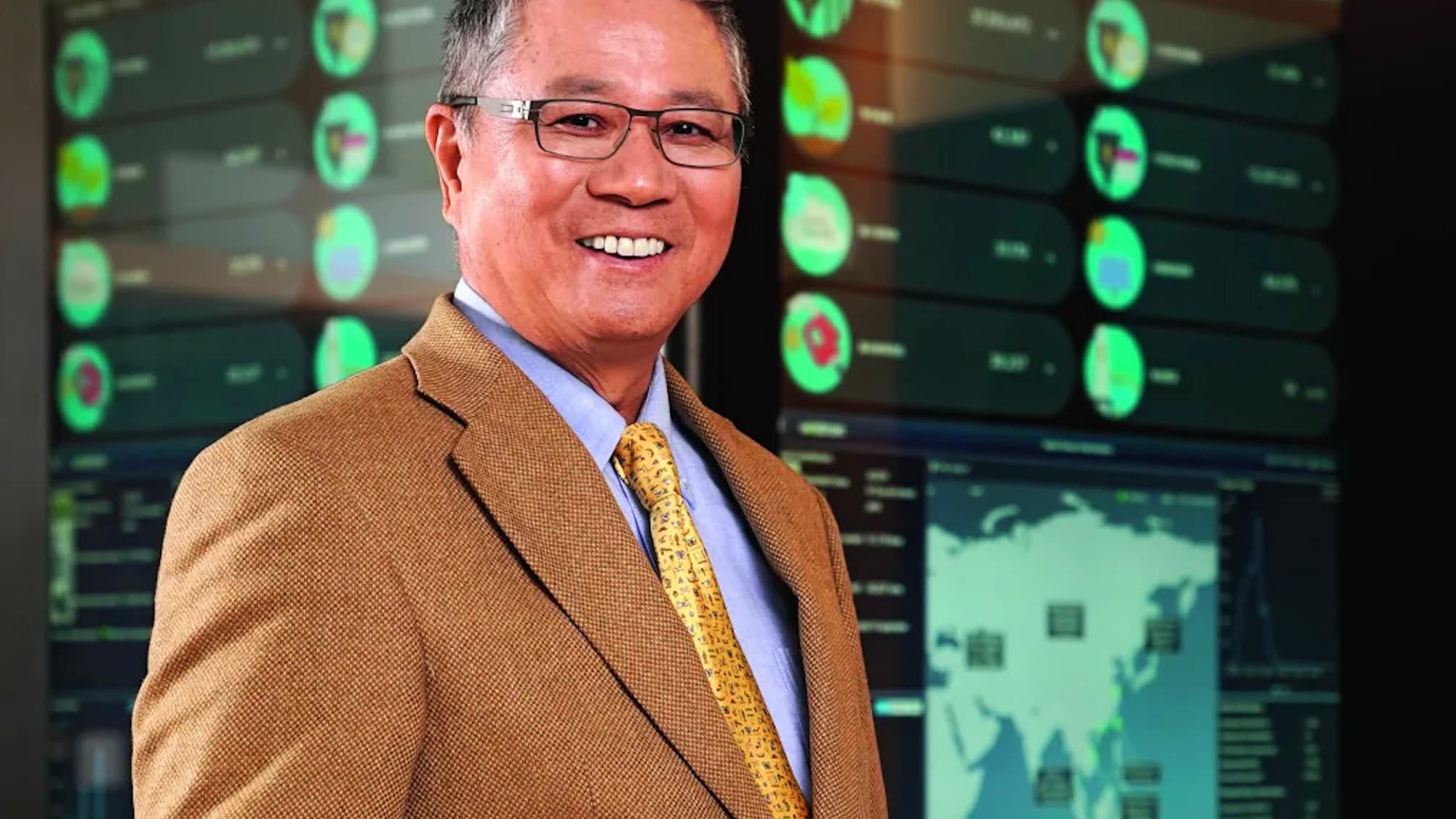 Wistron chairman Simon Lin standing in front of monitoring screens